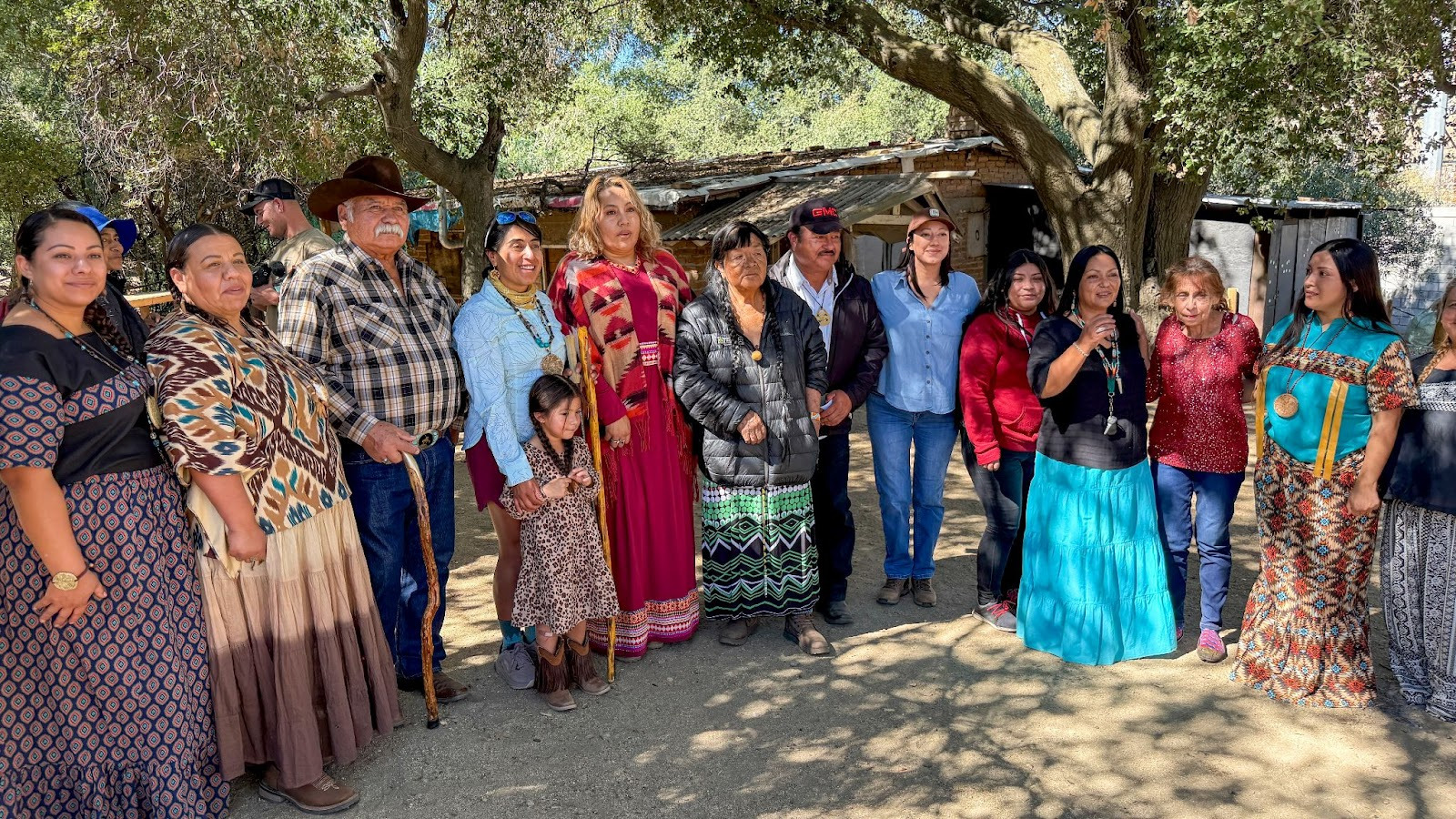 A dozen people of various ages standing and smiling in a group at kick off ceremony and celebration